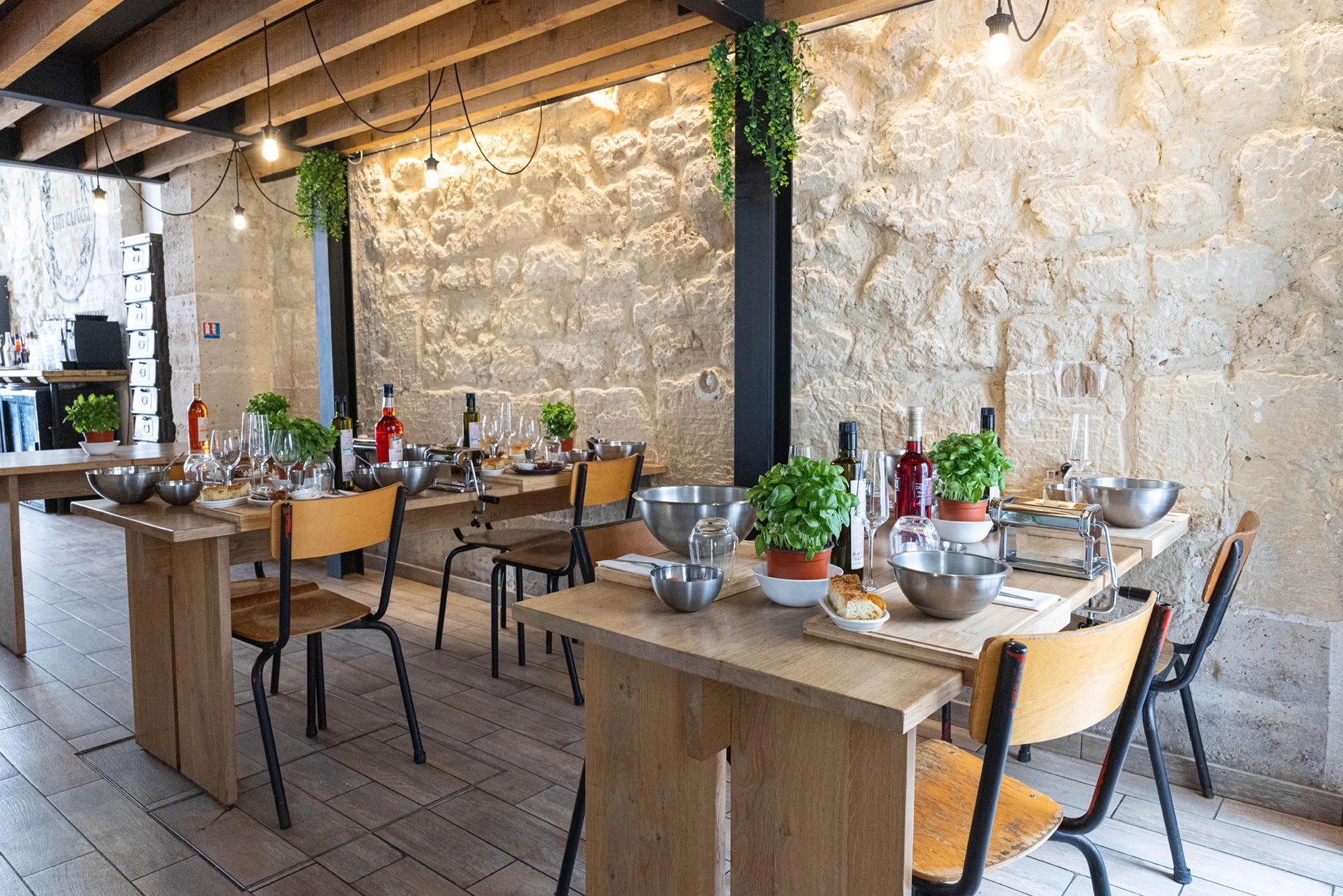 Atelier chaleureux de ravioli faits maison avec tables en bois, ustensiles et plantes aromatiques, ambiance naturelle et organisée.